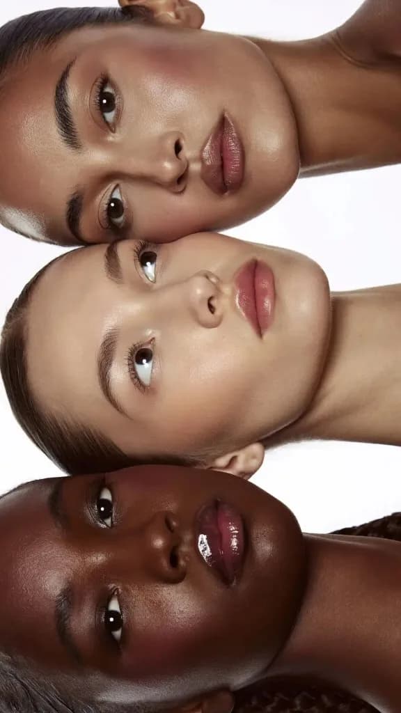 Skincare beauty campaign, three models with glowing skin photographed together in a bright studio setting