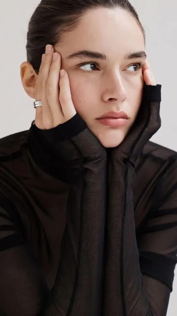 Studio portrait photography, model in a sheer black turtleneck resting her face in her hands, North East photography studio